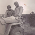 two officers reading map on jeep